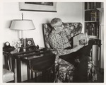 Pres Nels Minne at home reading paper